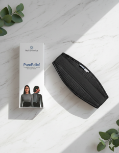 Neil Orthotics PureRelief back pain support belt next to its minimalist white product packaging on a marble surface with soft shadows.